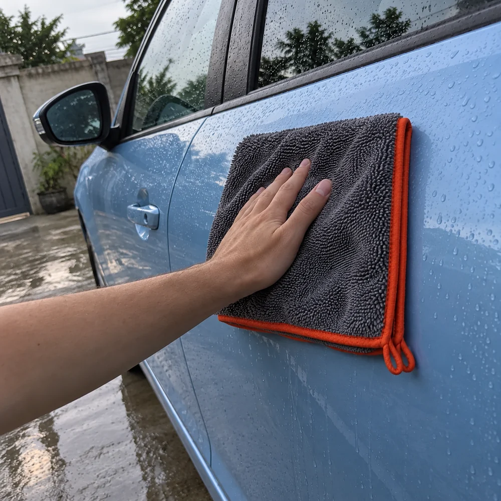 Cena ilustrativa de uma mão passando a toalha na porta limpa e enxaguada do carro
