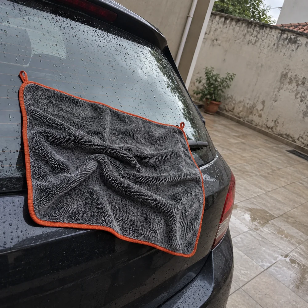 Cena ilustrativa da toalha sobre o vidro traseiro do carro no quintal